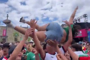 女球迷被一群男球迷抛向空中，结果把人妹子砸到一人头上